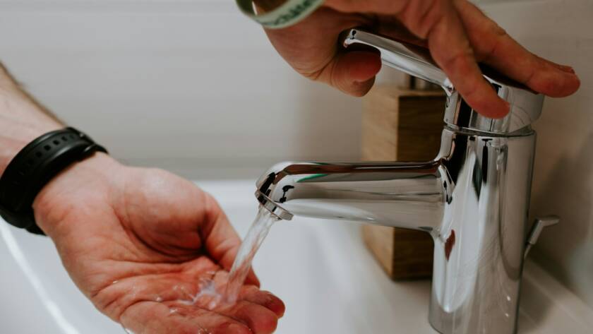 person holding stainless steel faucet