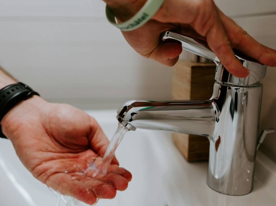 person holding stainless steel faucet