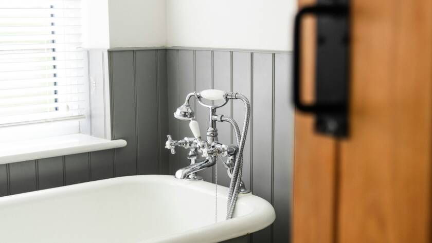 a bathroom with a claw foot tub and a wooden door