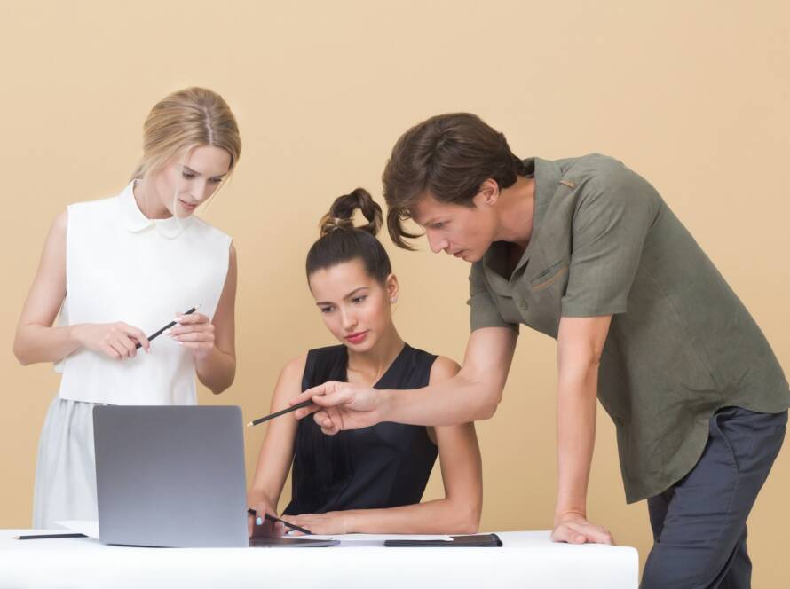 man teaching woman while pointing on gray laptop